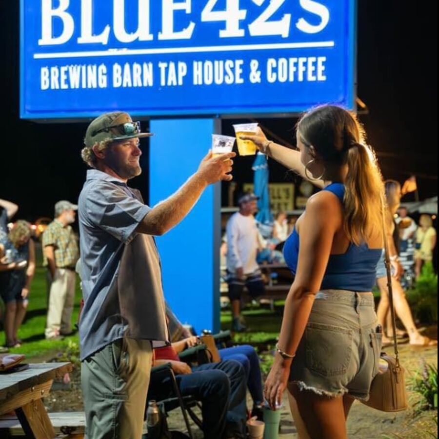 Friends toasting drinks together at Blue 42's Brewing Barn